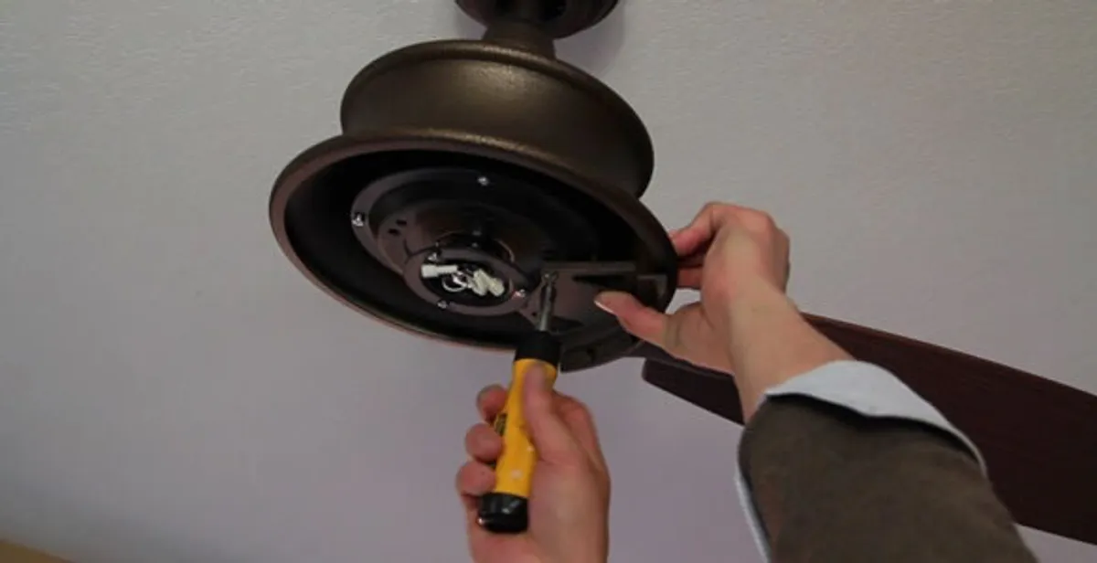 Electrician installing ceiling fan mounting bracket and fixture in Birmingham, AL